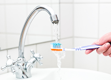 Rinsing toothbrush under tap